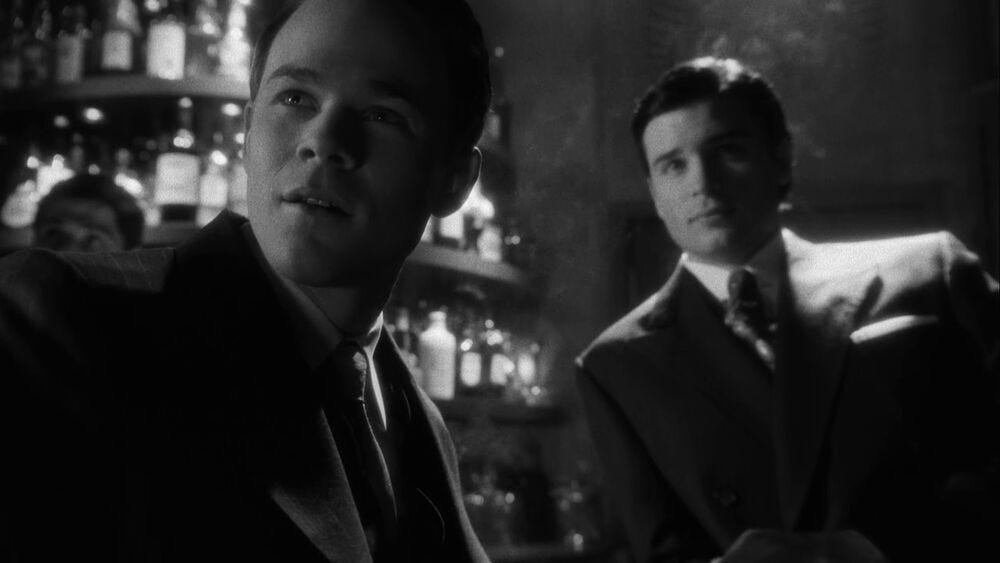 Black-and-white screengrab from the Smallville episode "Noir" featuring Jimmy Olsen and Clark Kent.