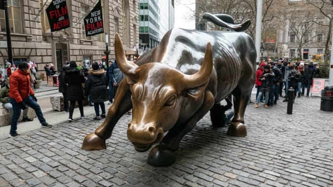 The Charging Bull bronze sculpture, also known as Wall Street Bull or Bowling Green Bull in New York City with tourists around taking photos of it.