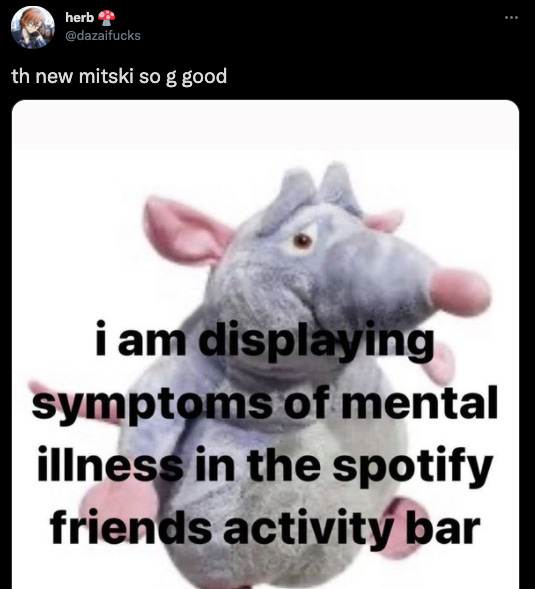 a screenshot of a tweet that says "th new mitski so g good" with an image of a stuffed rat that says "i am displaying symptoms of mental illness in the spotify friends activity bar"