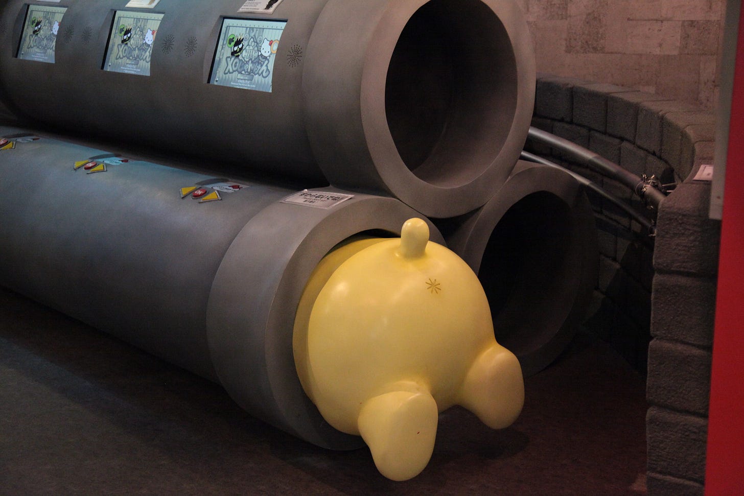 A sculpture of a cartoon character stuck in a pipe.