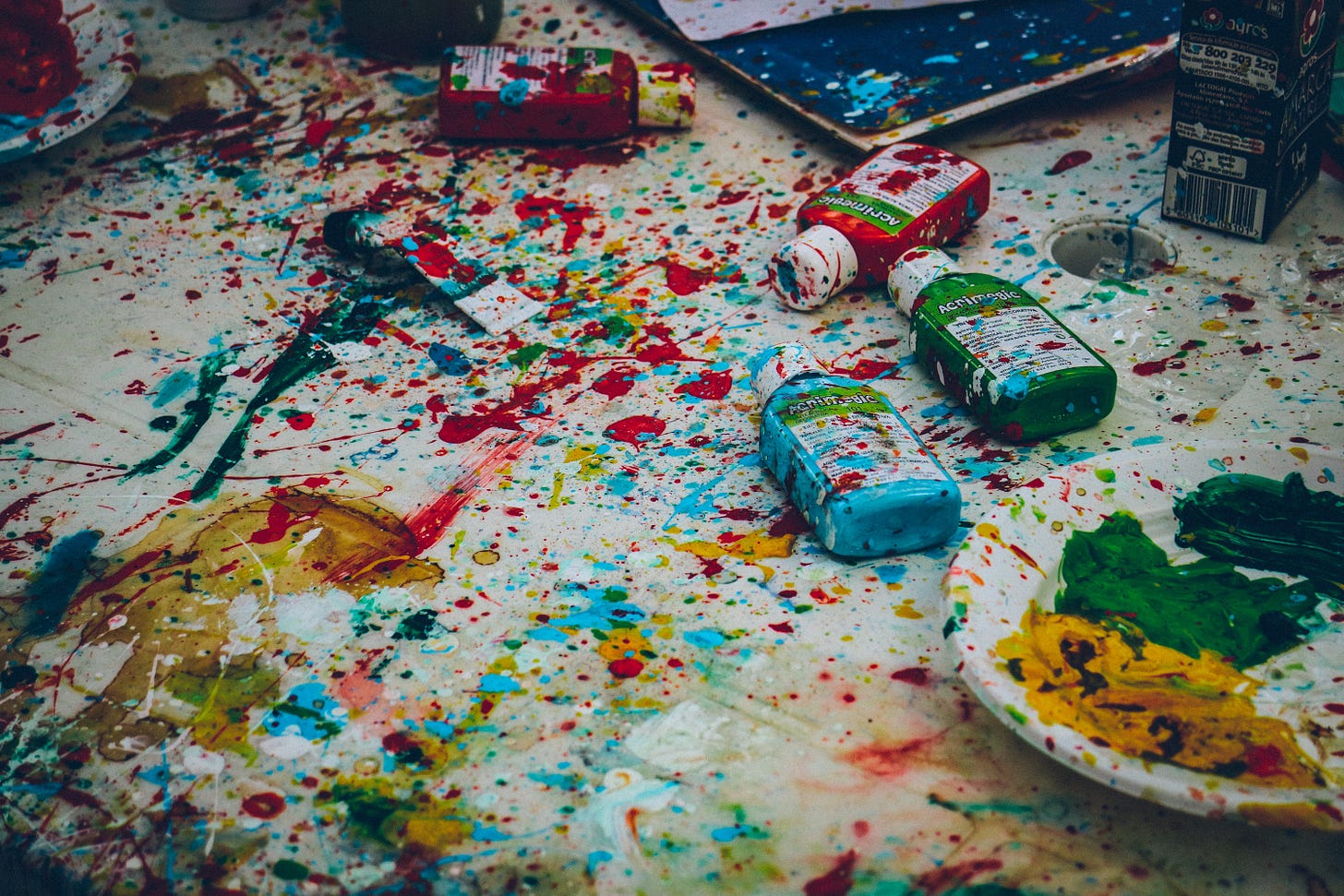 assorted-color bottles on white surface with paint scribbles photo