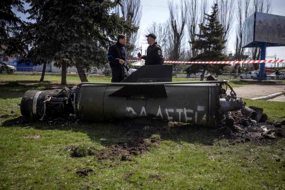 Ukrainian police inspecting a huge rocket at the scene