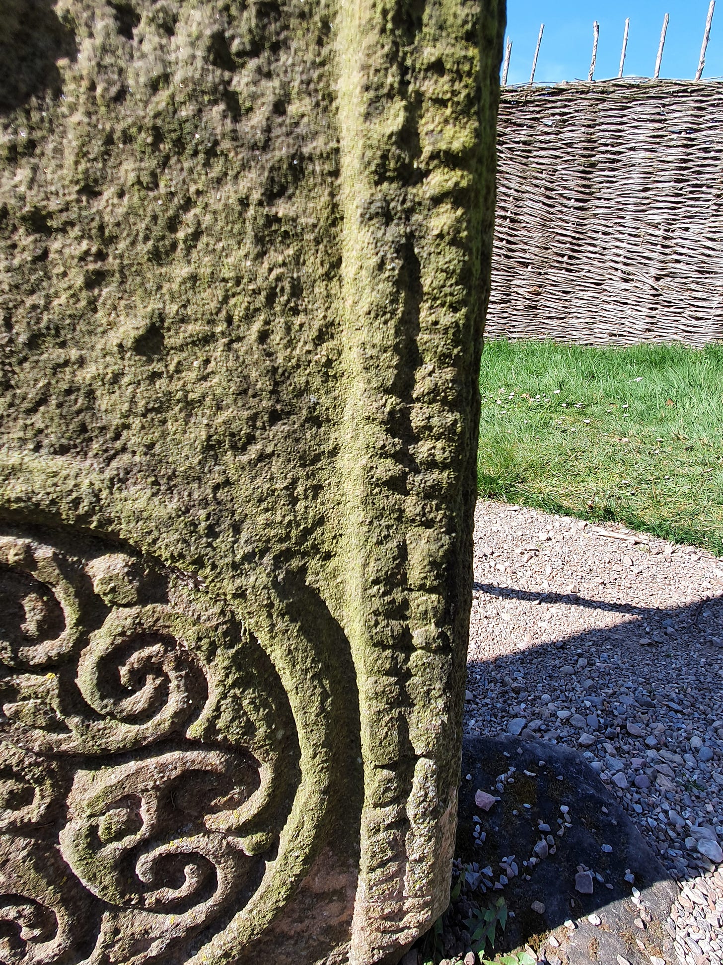 Section of ogham script, comprised of notches along a stem line, inscribed into the edge of the symbol-bearing face of Rodney’s Stone