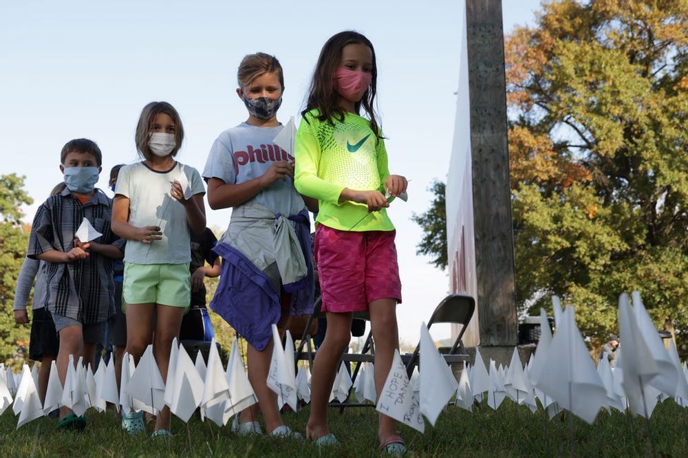 Children plant 240,000 flags on Friday in Washington DC to memorialize Americans killed by SARS-CoV-2