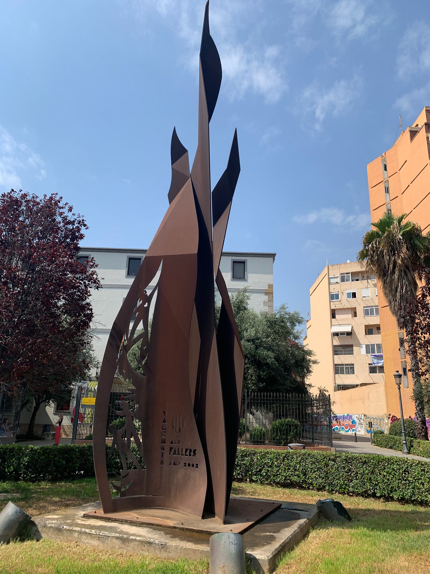 A metal sculpture in the form of a giant flame stands in front of the Museu