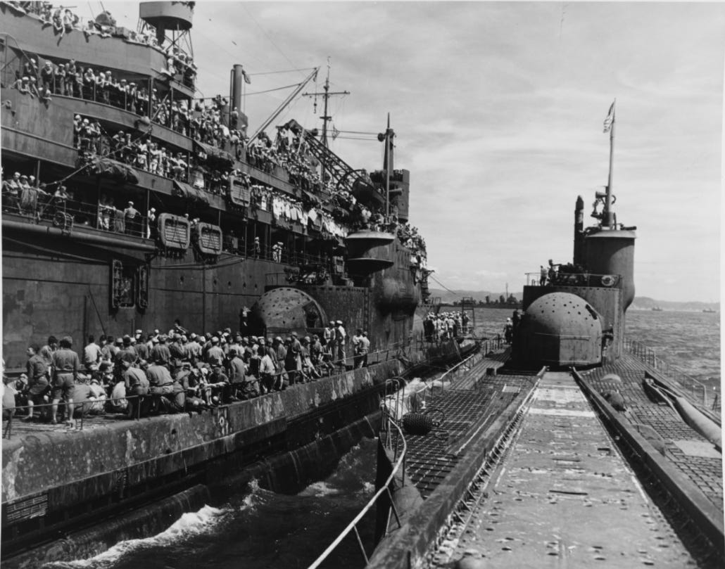 U.S. Navy submarine tender USS Proteus is depicted alongside the Japanese submarines I-400 and I-401.