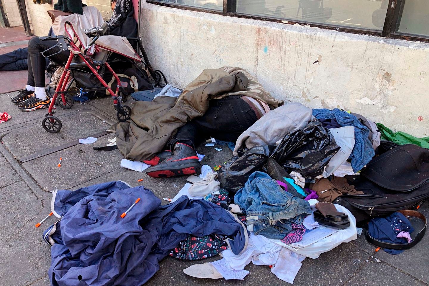People slept near discarded clothing and used needles on a street in the Tenderloin neighborhood in San Francisco in 2019.