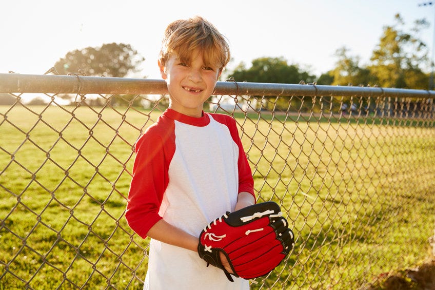 Boy holding baseball and glove