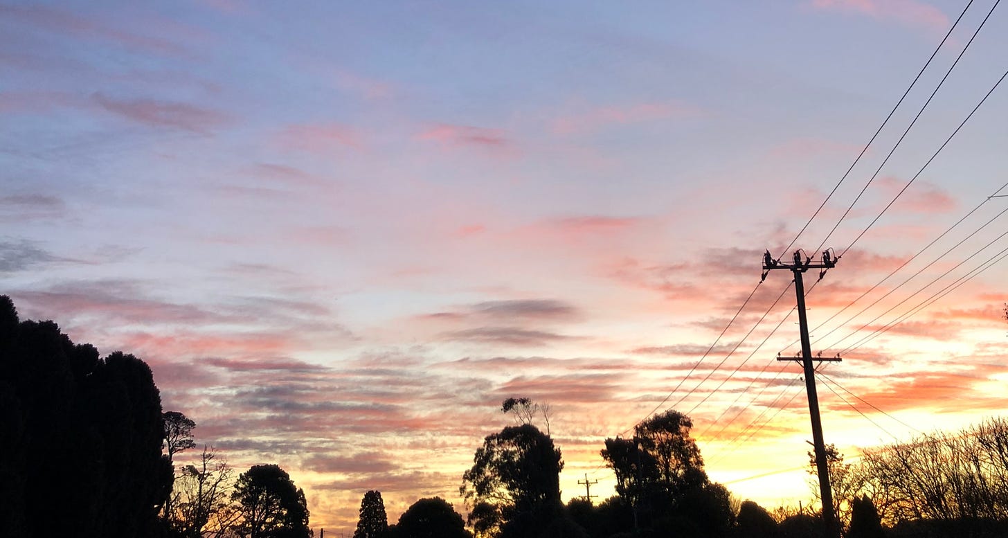 Sunset on a suburban street - power lines silhouetted against a beautiful orange and purple sky
