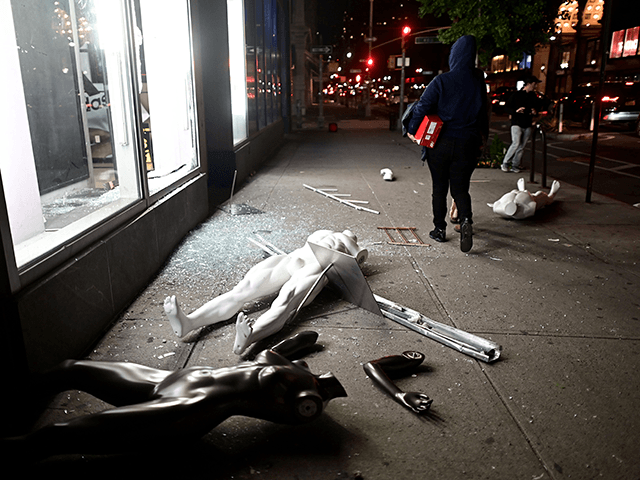 Looters walk next to a smashed store in Lower Manhattan on June 1, 2020, after a after demonstrations over the death of George Floyd by a Minneapolis police officer on June 1, 2020 in New York. - New York's mayor Bill de Blasio today declared a city curfew from 11:00 …