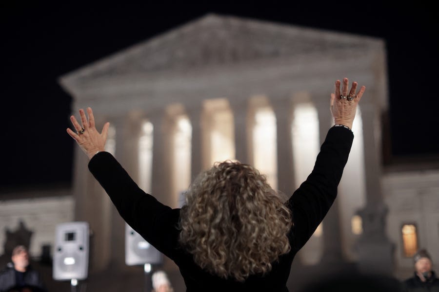 A woman raises her hands in prayer as she joins other anti-abortion activists during a candlelight vigil organized by the Purple Sash Revolution outside the U.S. Supreme Court on Nov. 30, 2021 in Washington, D.C.