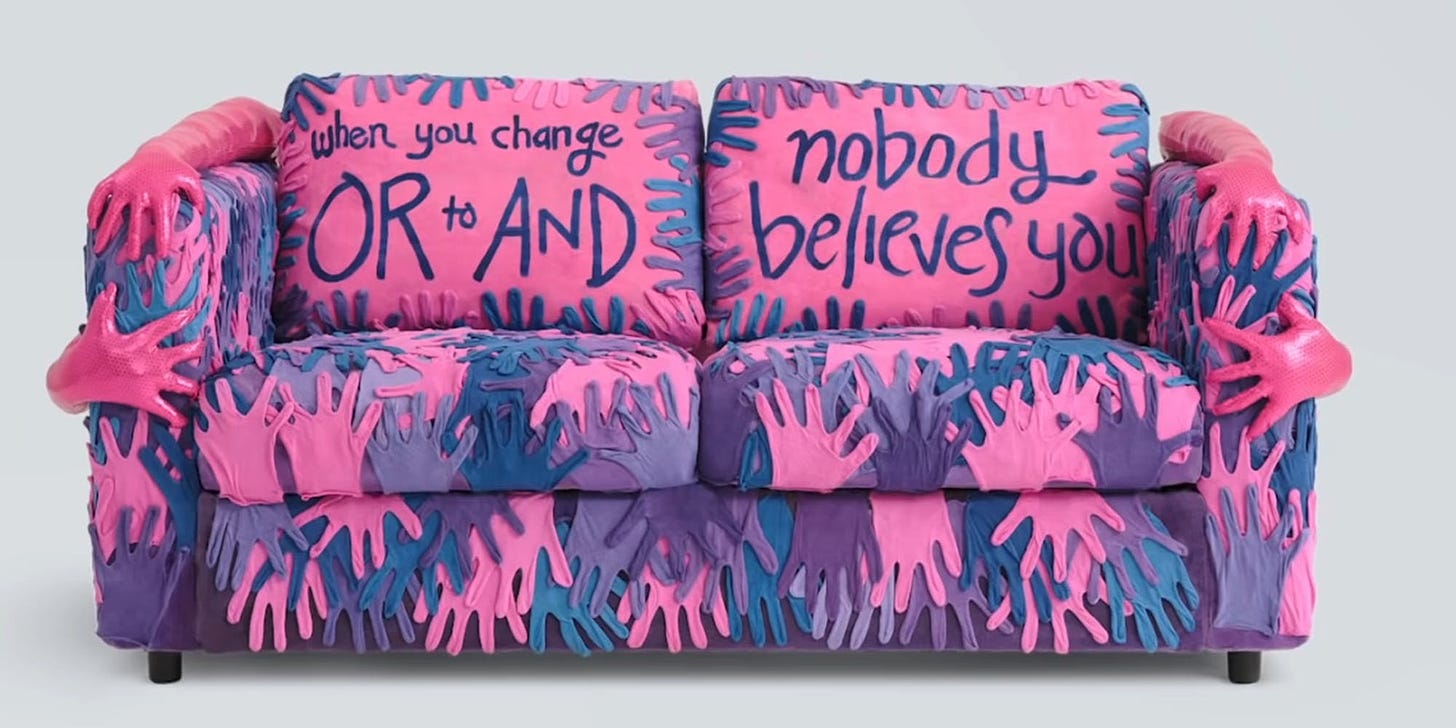 A loveseat covered with hand shapes in blues, pinks and purples, with molded 3D hand sculptures on the arms. The back cushions read "When you change OR to AND / nobody believes you."