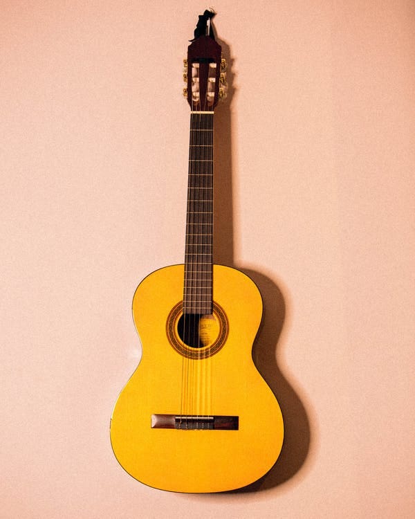 Foto De Guitarra Amarela Pendurada Na Parede Rosa