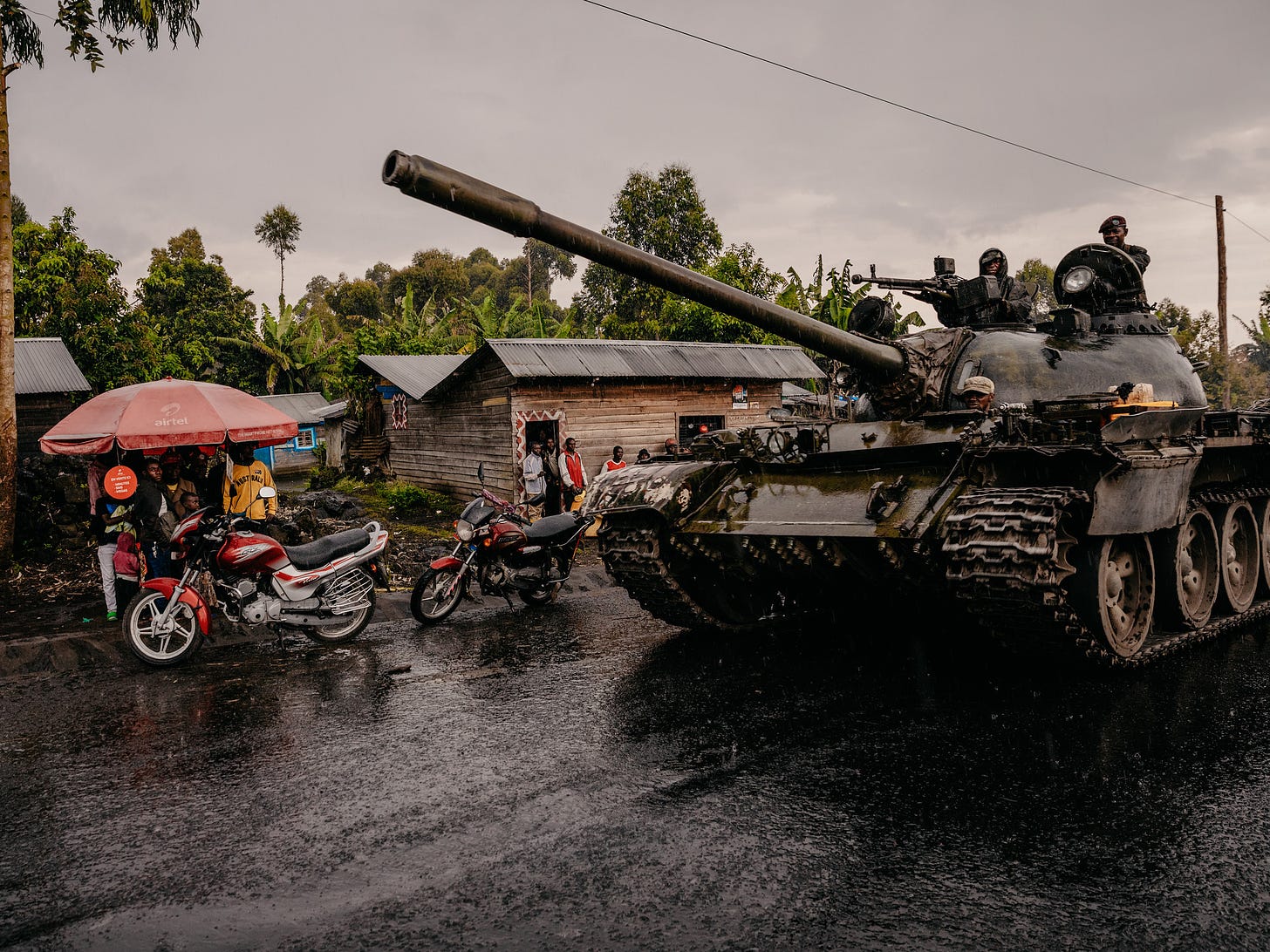 Congolese Army units (FARDC) drive past civilians