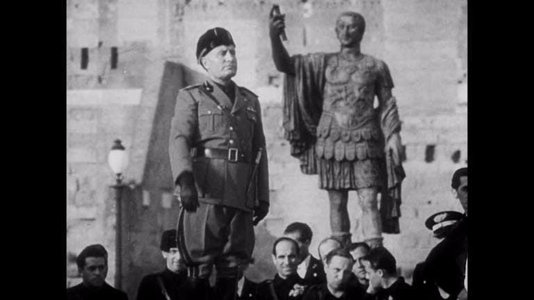 Benito Mussolini Stands Beside Statue of Julius Caesar