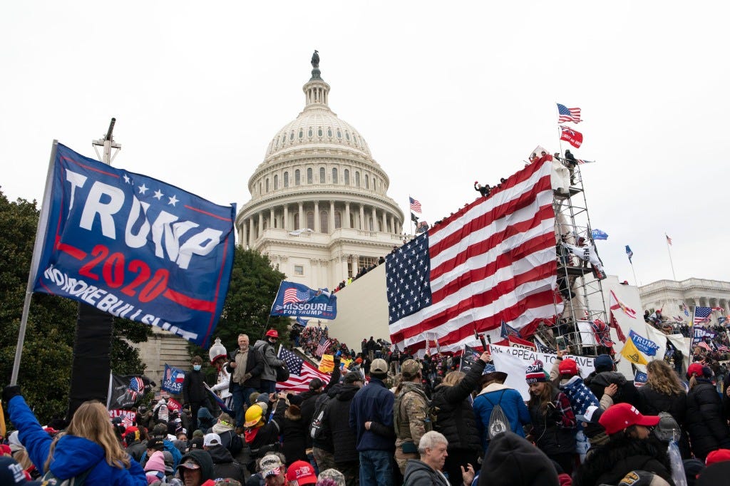 Violent insurrectionists loyal to President Donald Trump stand outside the U.S. Capitol in Washington on Jan. 6, 2021. 
