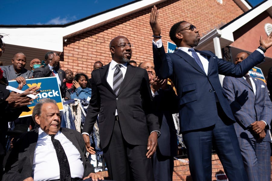 Sen. Raphael Warnock, D-Ga., center, prepares to speak at a rally after being introduced by Civil Rights icon Andrew Young, left, and Atlanta Mayor Andre Dickens on Sunday, Nov. 27, 2022, in Atlanta.