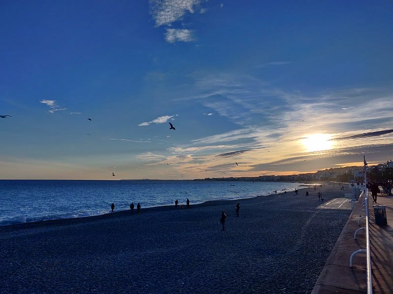 Photo d'un coucher du soleil au bord de la plage à Nice
