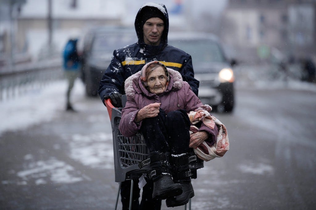 An elderly woman is carried in a shopping cart after being evacuated from Irpin, on the outskirts of Kyiv, Ukraine on March 8, 2022.