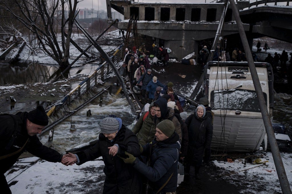 Ukrainians cross an improvised path under a destroyed bridge while fleeing Irpin, in the outskirts of Kyiv, Ukraine on March 8, 2022.