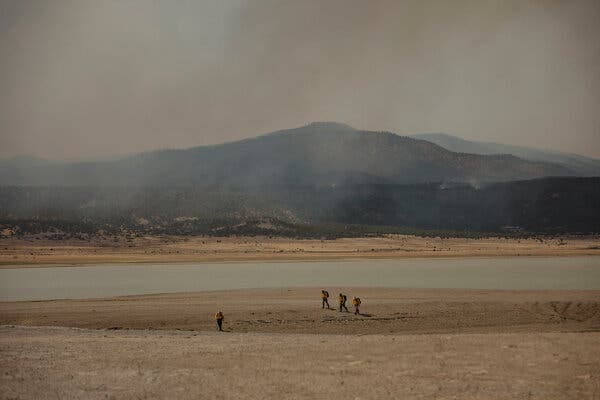 Crews raced to the fire lines as ash fell from a sky that shifted from bright blue to a surreal orange hue.
