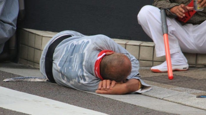 Japanese traffic worker taking a nap on the crosswalk