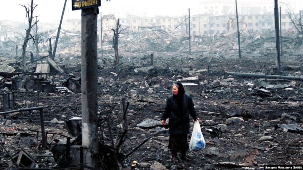 A woman picks her way through the rubble in Grozny during the Second Chechen War in February 2000. 