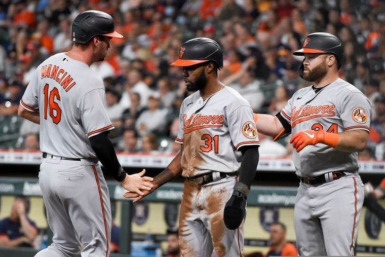 Baltimore Orioles' Trey Mancini, left, celebrates scoring a run on Ryan Mountcastle's two-run double with Cedric Mullins (31) and DJ Stewart during the first inning of a baseball game against the Houston Astros, Wednesday, June 30, 2021, in Houston. (AP Photo/Eric Christian Smith)