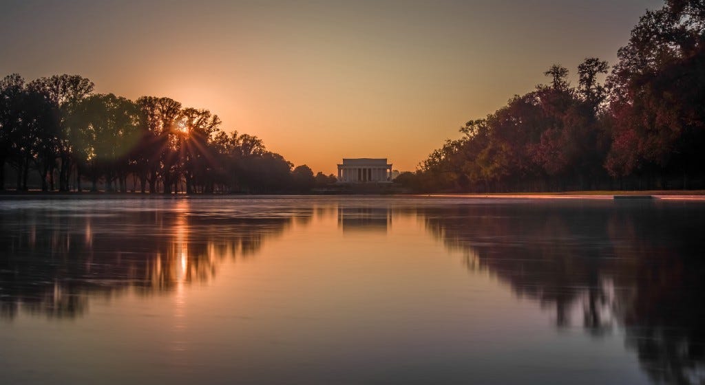 Photo of the Lincoln Memorial at sunset from a low angle over the water
