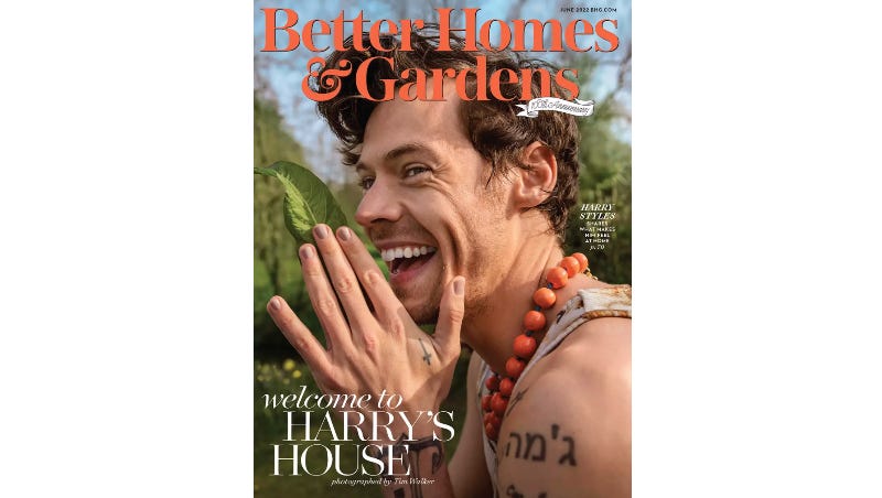 close up headshot photo of British singer Harry Styles smiling on the cover of magazine Better Homes & Gardens wearing an orange pearl necklace