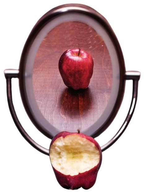 An apple with a bite out of it looks whole in a mirror