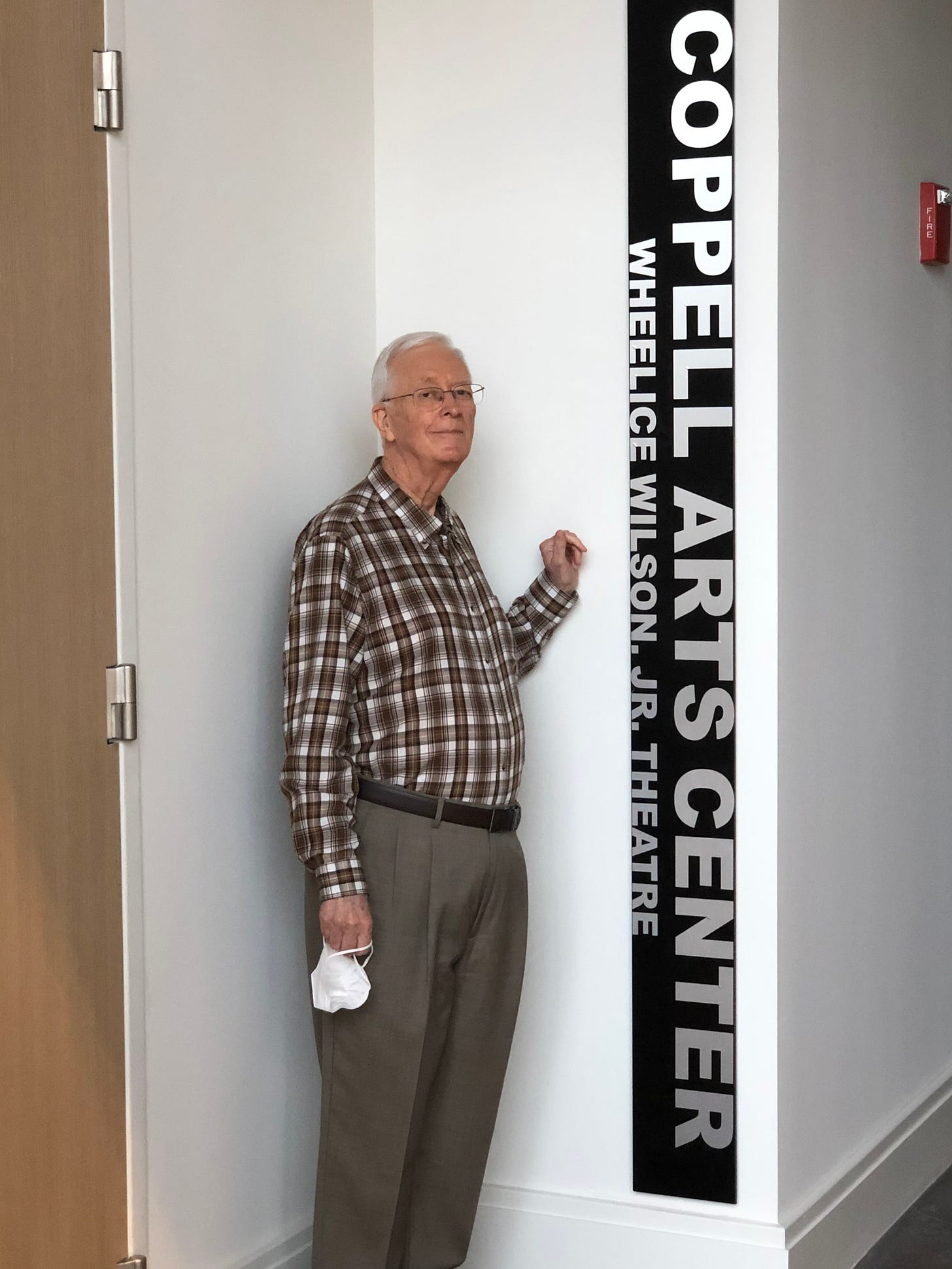 Wheelice Wilson Jr. standing next to a sign bearing his name at the Coppell Arts Center