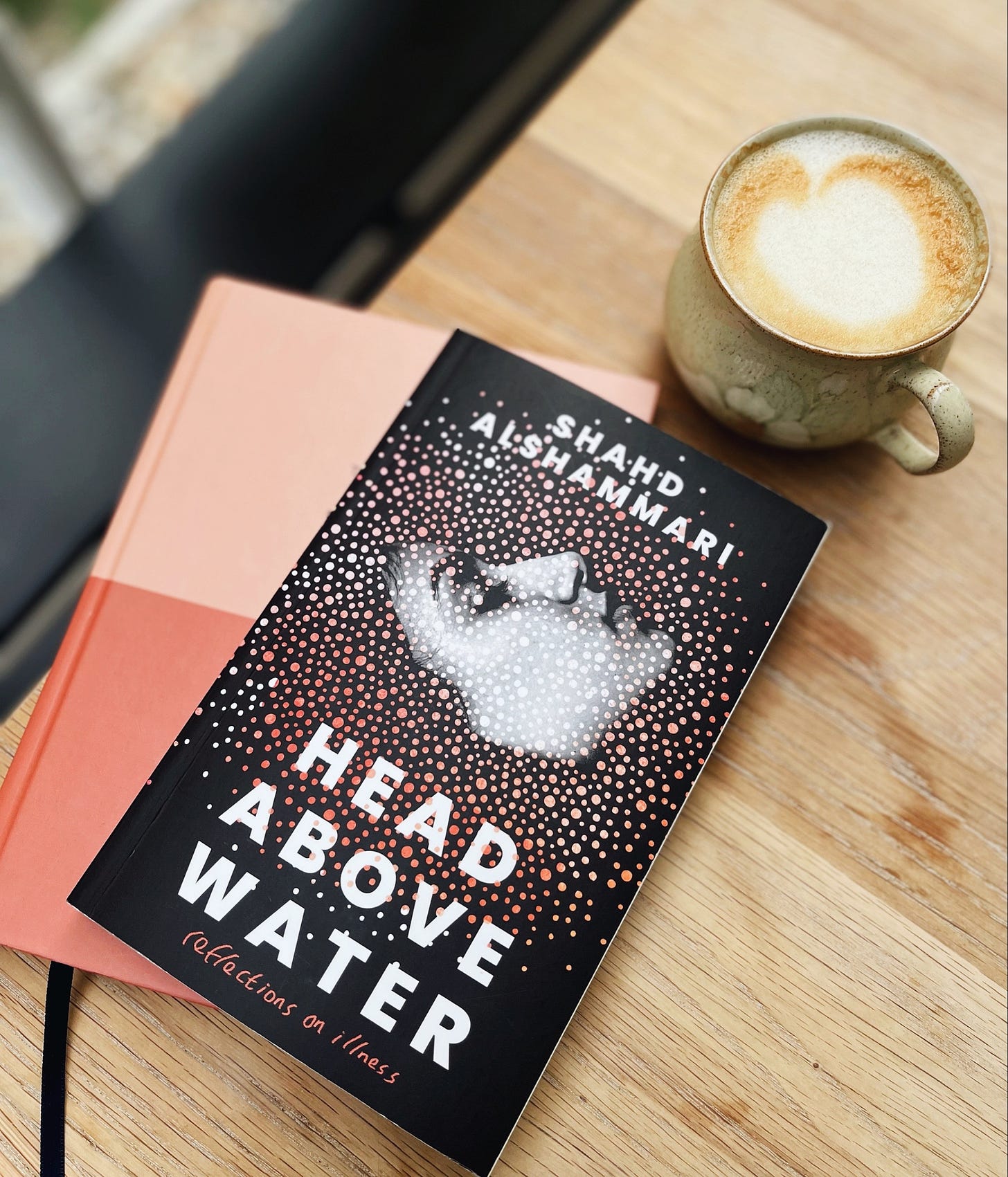 A copy of Head Above Water beside a cup of coffee
