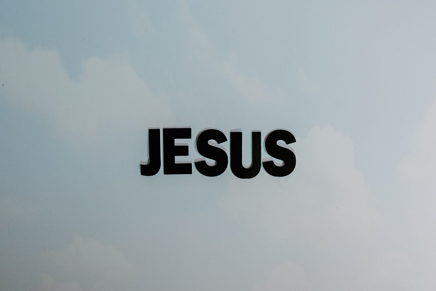 The word "Jesus" on a cloud background.
