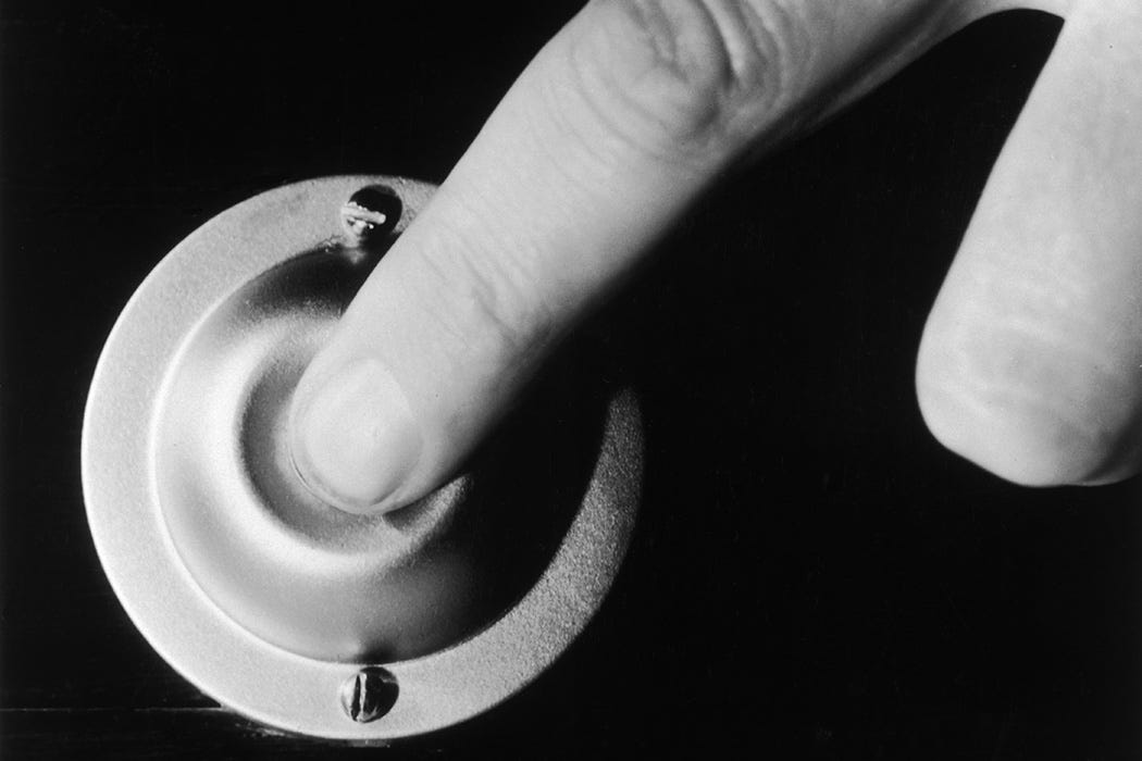 A finger pressing a doorbell, circa 1950.