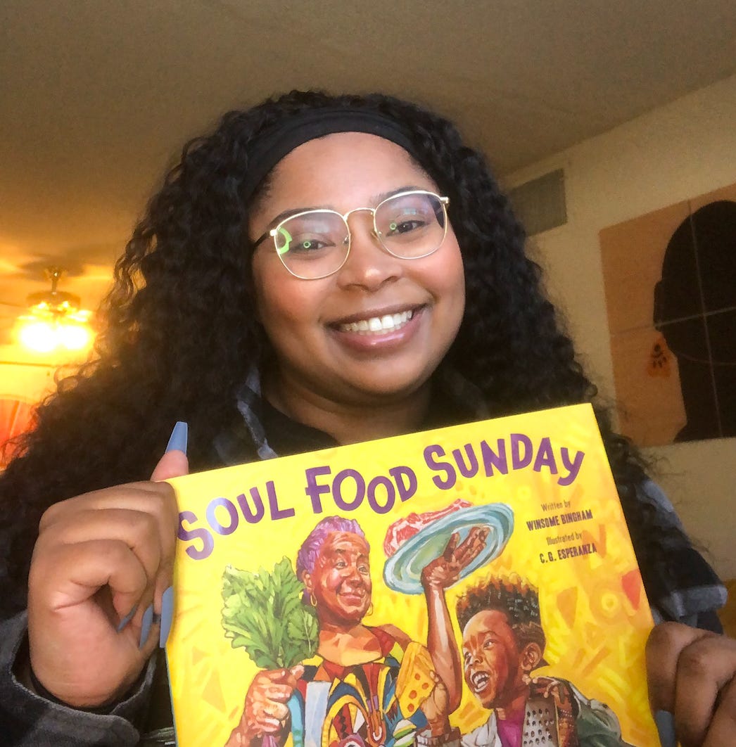 Margarett holding up a copy of the children's book "Soul Food Sunday."