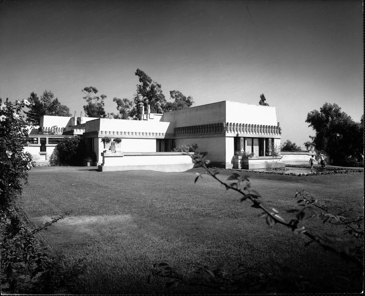 Hollyhock House from downhill with children playing in pool, 1921