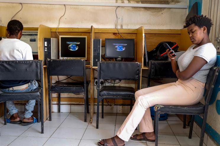 A customer uses the Wi-Fi on her mobile phone at an internet cafe in the low-income Kibera neighborhood of Nairobi, Kenya on Sept. 29, 2021. Facebook has failed to catch Islamic State group and al-Shabab extremist content in posts aimed at East Africa as the region remains under threat from violent attacks and Kenya prepares to vote in a closely contested national election, according to a new study released Wednesday, June 15, 2022.