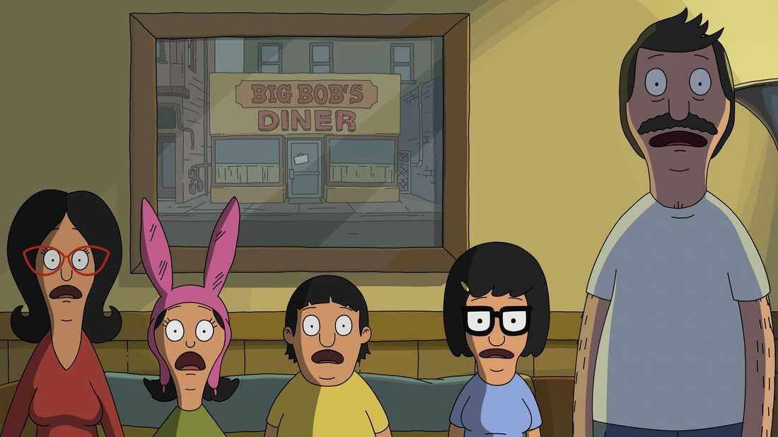 a screenshot of the bob's burgers movie, showing linda, louise, gene, tina and bob on their couch staring at the tv off screen with shocked expressions.