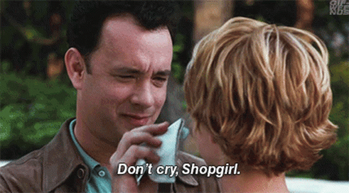 gifje uit de film You've got mail waarin Tom Hanks die met een zakdoek de ogen van Meg Ryan droogt. Hij zegt Don't Cry, Shopgirl. De tekst staat onderaan in wit.