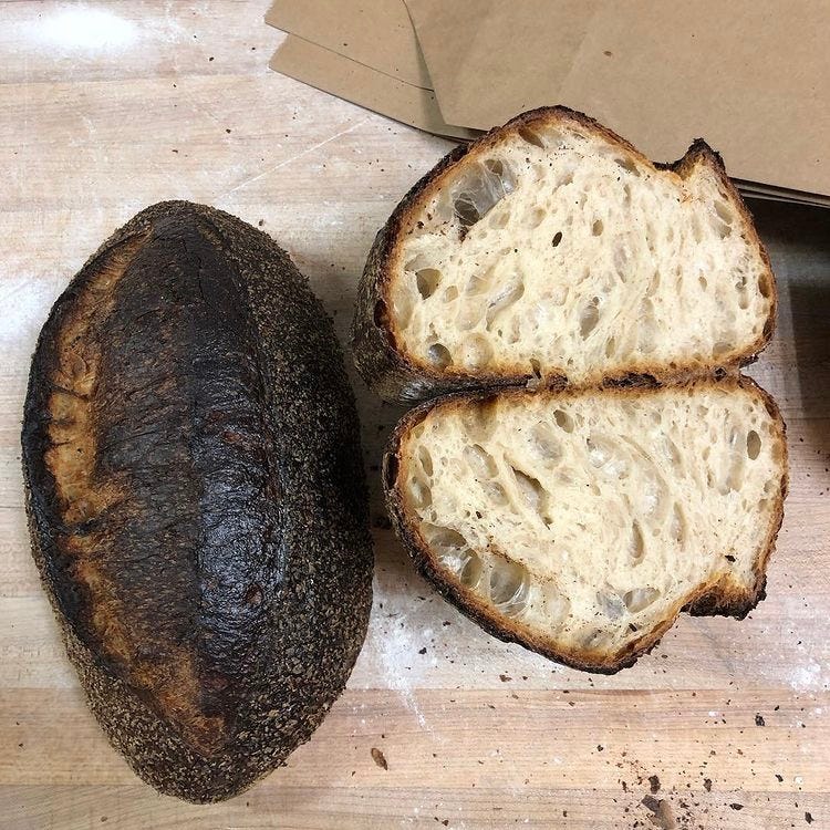 Charred loaf on the left, and a sliced charred loaf on the right where you can see the perfect interior that I cried into after I took this photo.
