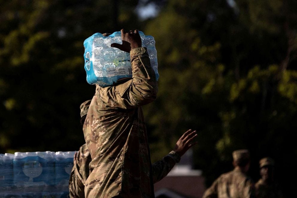 PHOTO: A member of the National Guard carries bottles of drinking water at a distribution site in Jackson, Mississippi, Sept. 1, 2022. 