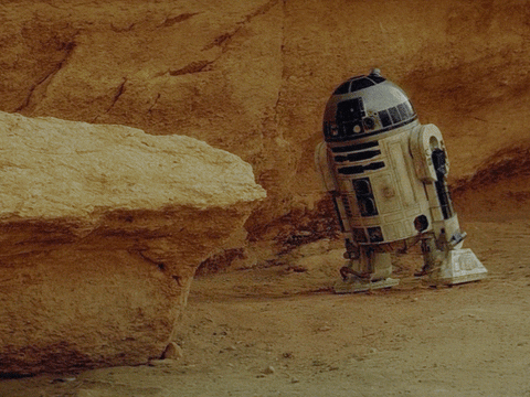 R2D2 from Star Wars falls over in front of red rock