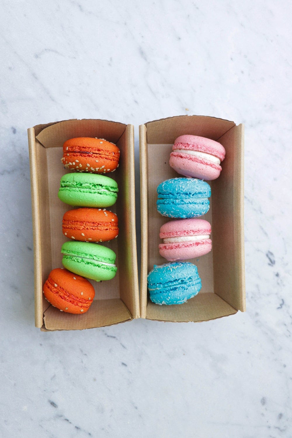 pink blue and yellow macaroons in box
