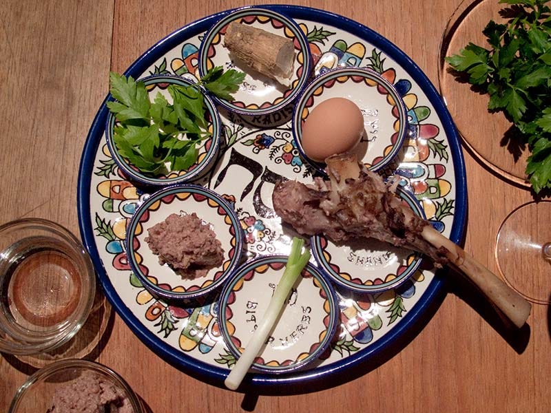 overhead shot of passover seder plate with all of the symbolic foods