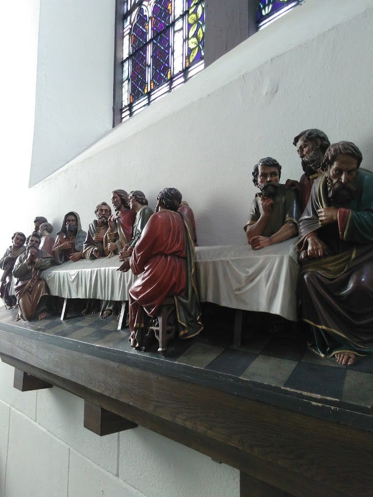 Painted sculpture of the Last Supper with Jesus and the twelve apostles.