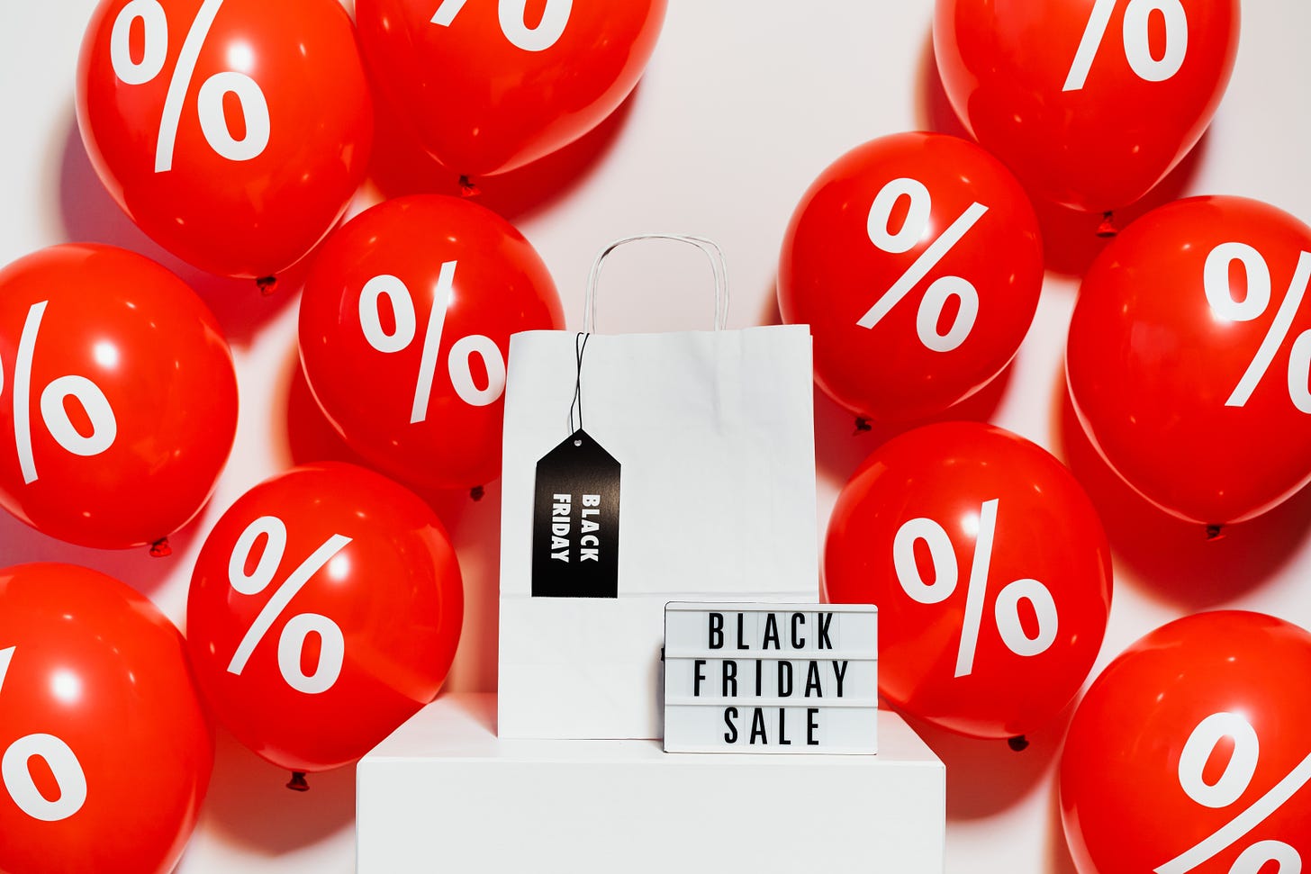 Red balloons behind a Black Friday Sale sign.