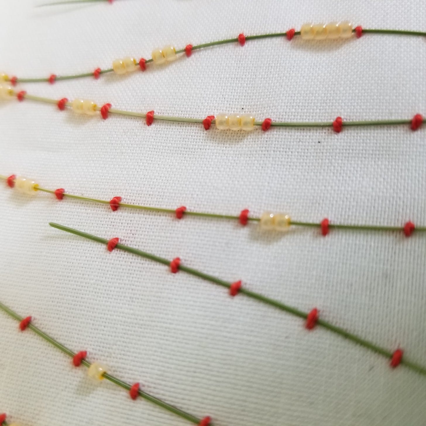 dried grass couched to muslin fabric with pink thread and peach glass beads