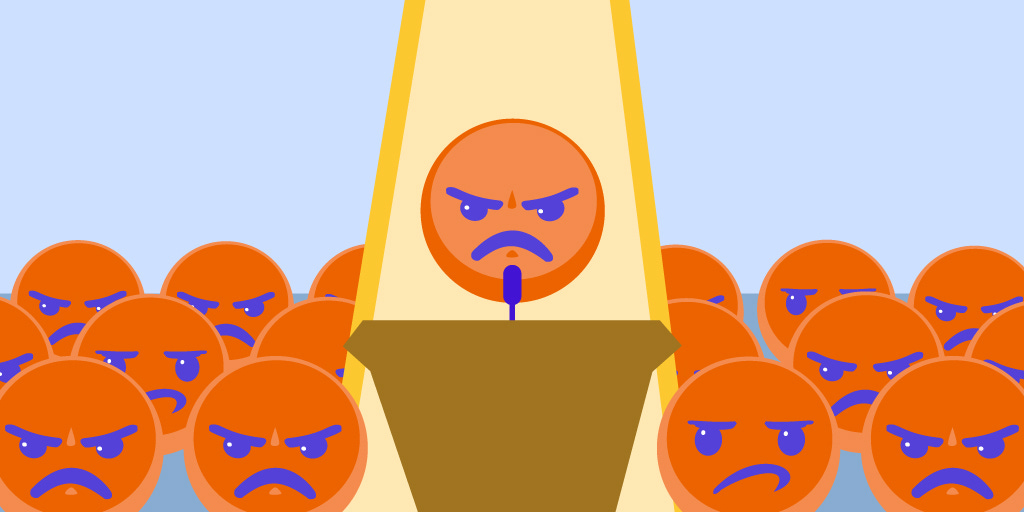 An illustration featuring orange angry emoji faces with blue features. They’re crowded around a podium, where one of them is poised to speak, in a yellow spotlight