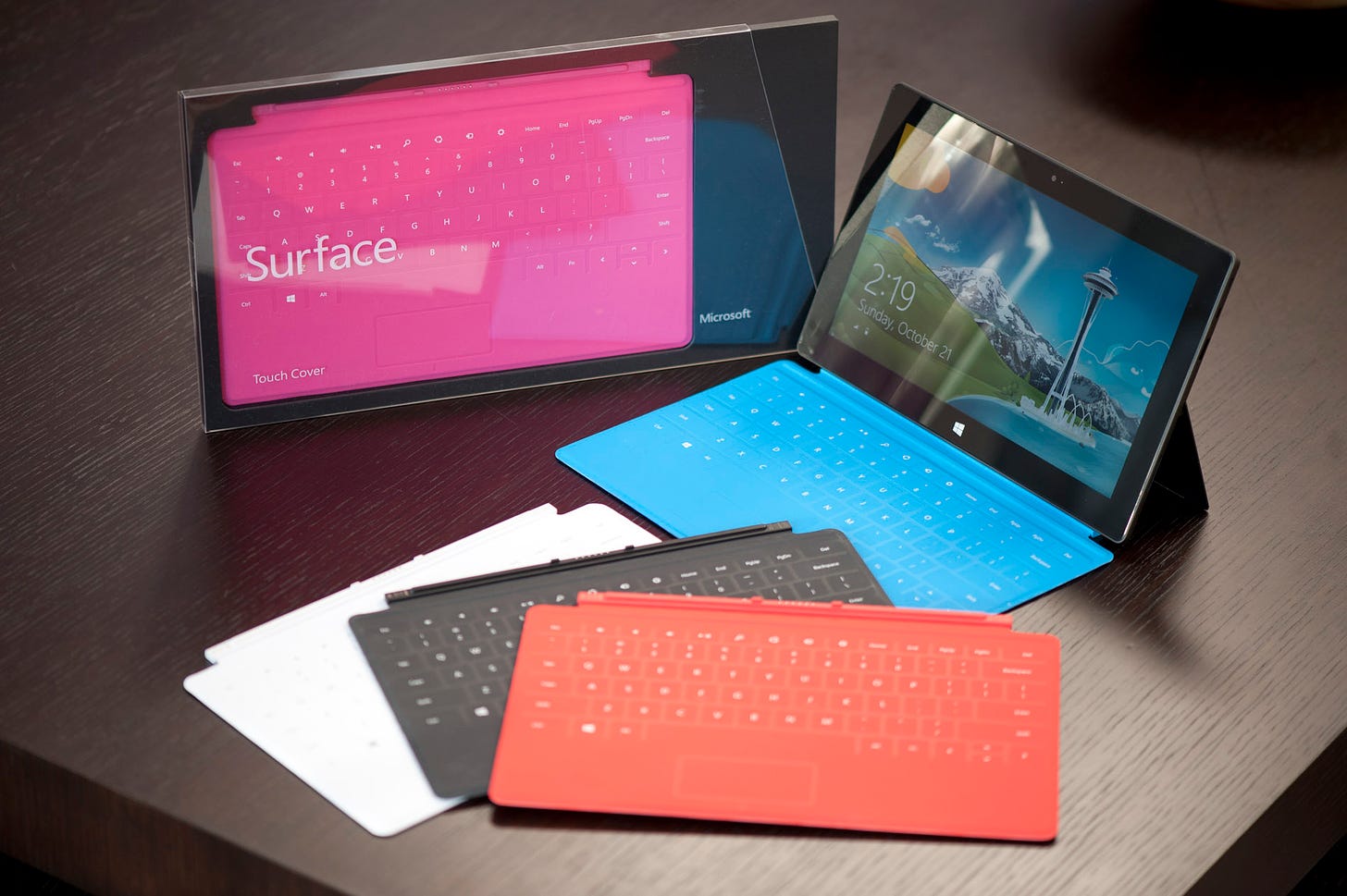 A photo of the retail box for Surface, the surface computer with a touch cover and positioned for typing. There are additional covers around the surface showing the colors.